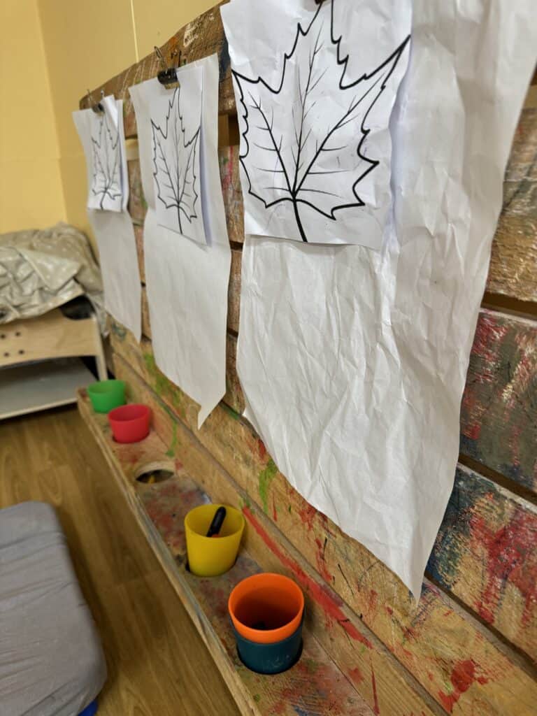 1. Colouring activity at Thrive Childcare featuring images of leaves on paper, promoting creativity and fine motor skills.