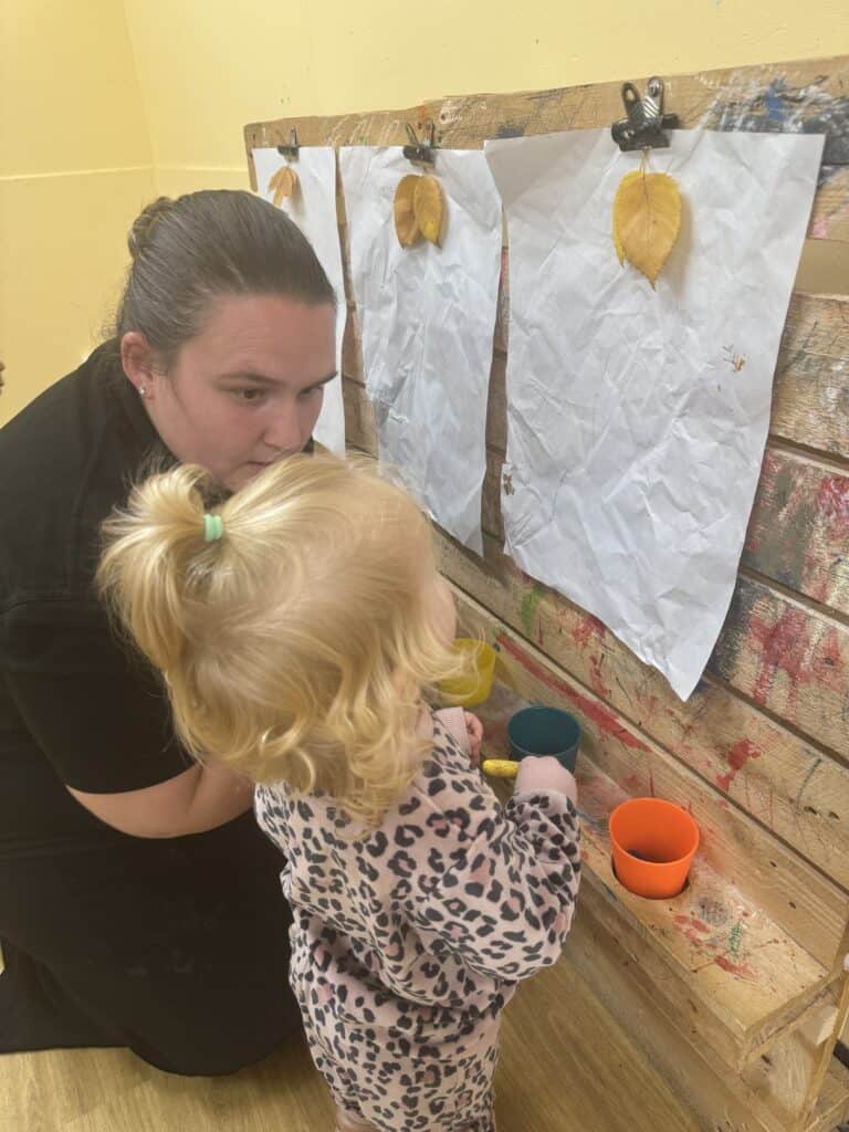 Bright preschool classroom activity with young children, colourful cups, artwork display, creative learning environment at Thrive Childcare centre, fostering early childhood development.