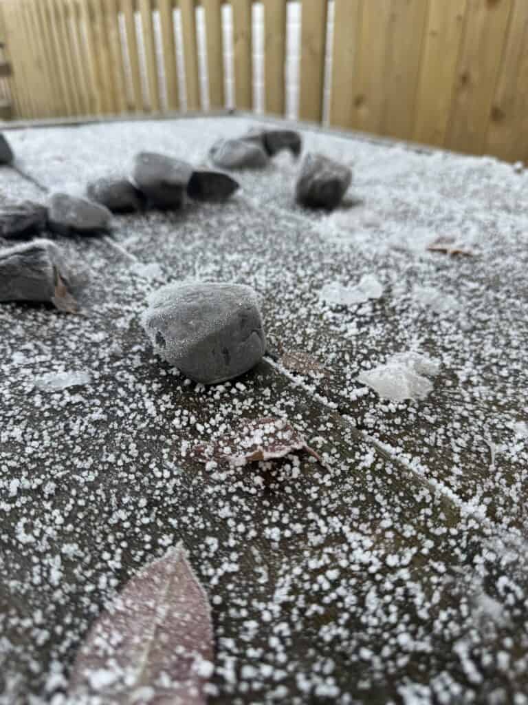 Wet gravel surface with scattered pebbles and snow, outdoor play area at Thrive Childcare, fostering active outdoor activities for early childhood development.
