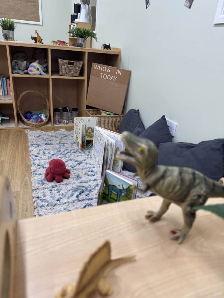1. Friendly indoor preschool play area with dinosaur toys, children's books, and cosy cushions, designed for early childhood learning and development.