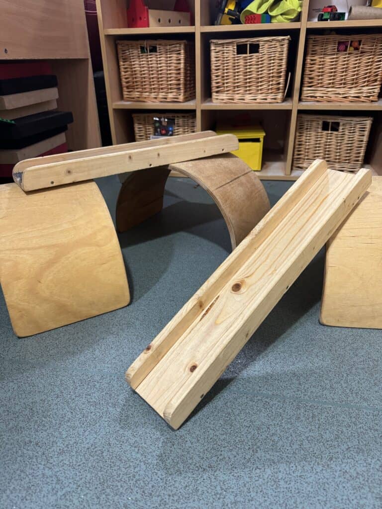 1. Natural wooden vestibular balance beam designed for early childhood development and sensory play in childcare settings.