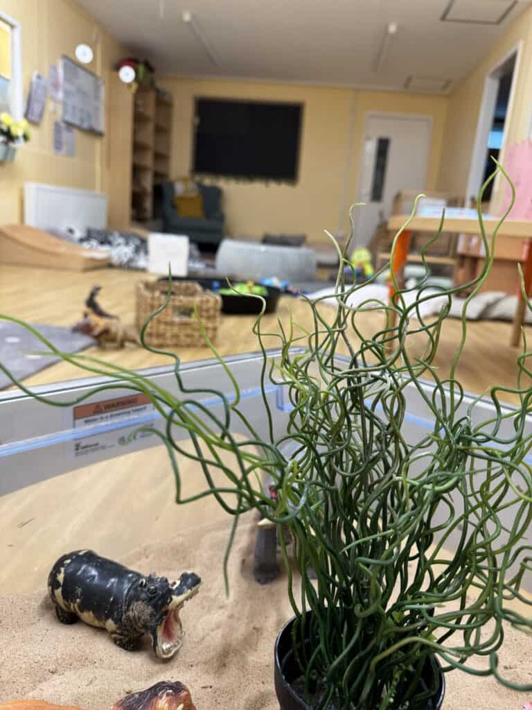 Vibrant, eco-friendly indoor play area at Thrive Childcare with engaging toys, comfortable seating, and a warm atmosphere that promotes child's development and learning.