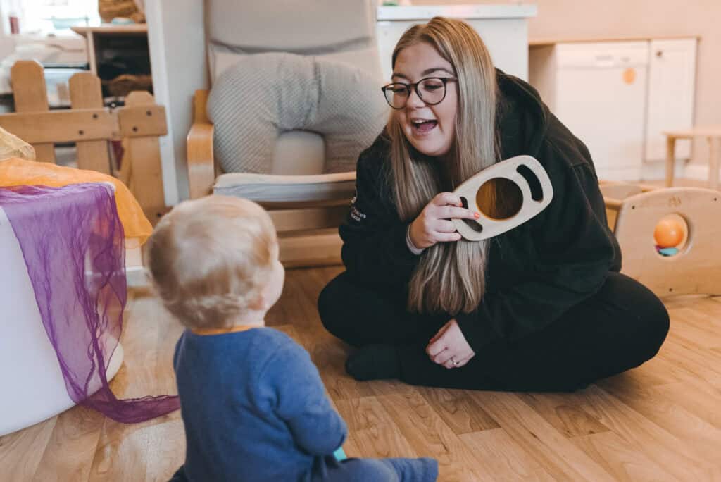 1. Young woman playing with a toddler at Thrive Childcare, engaging in educational activities for early childhood development.