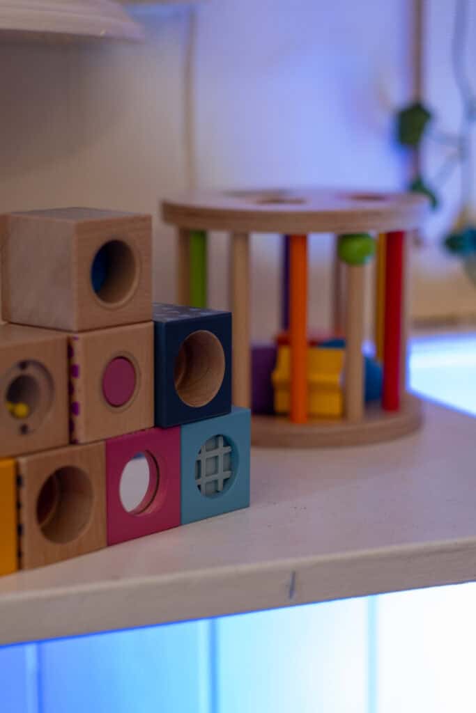 Bright wooden stacking blocks and a colourful wooden activity centre at Thrive Childcare, fostering early childhood development and play-based learning for young children.