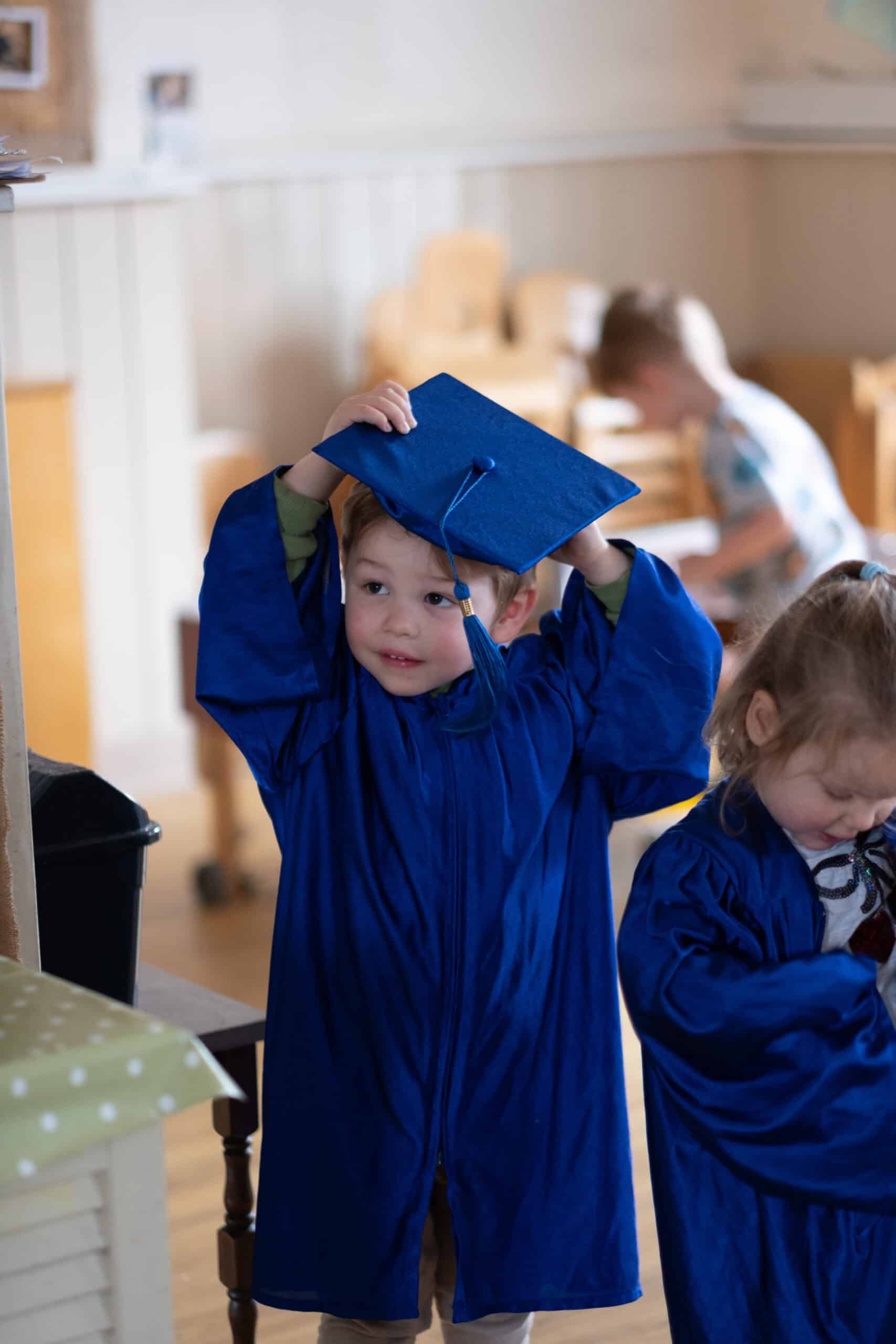 Graduating young children in blue caps and gowns at Thrive Childcare, celebrating milestones, development, and early childhood education in a nurturing environment.
