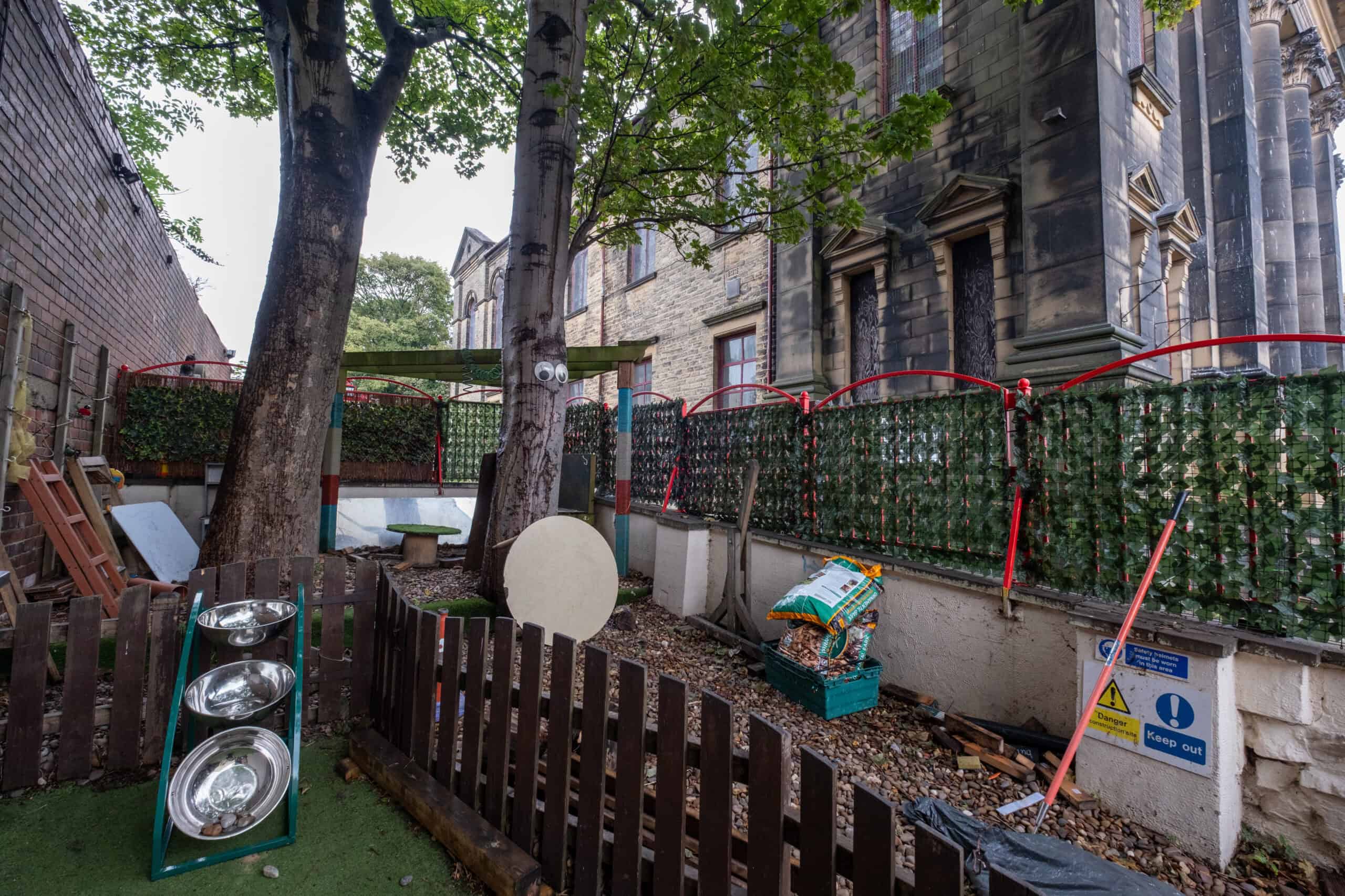 Bright outdoor play area at Thrive Childcare with trees, fencing, and playful elements for children’s outdoor activities and exploration.