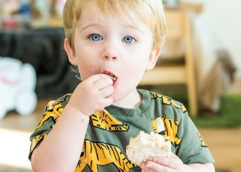 Bright young boy enjoying a snack at Thrive Childcare, with a cheerful environment ideal for early childhood education and development.