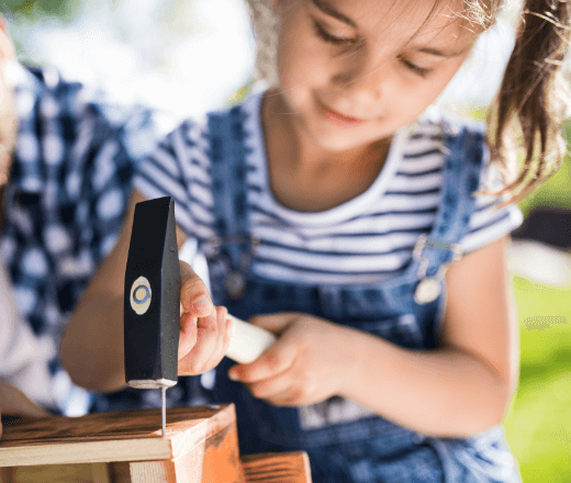 Young girl engaging in woodworking activity at Thrive Childcare, promoting hands-on learning, creativity, and early childhood development.