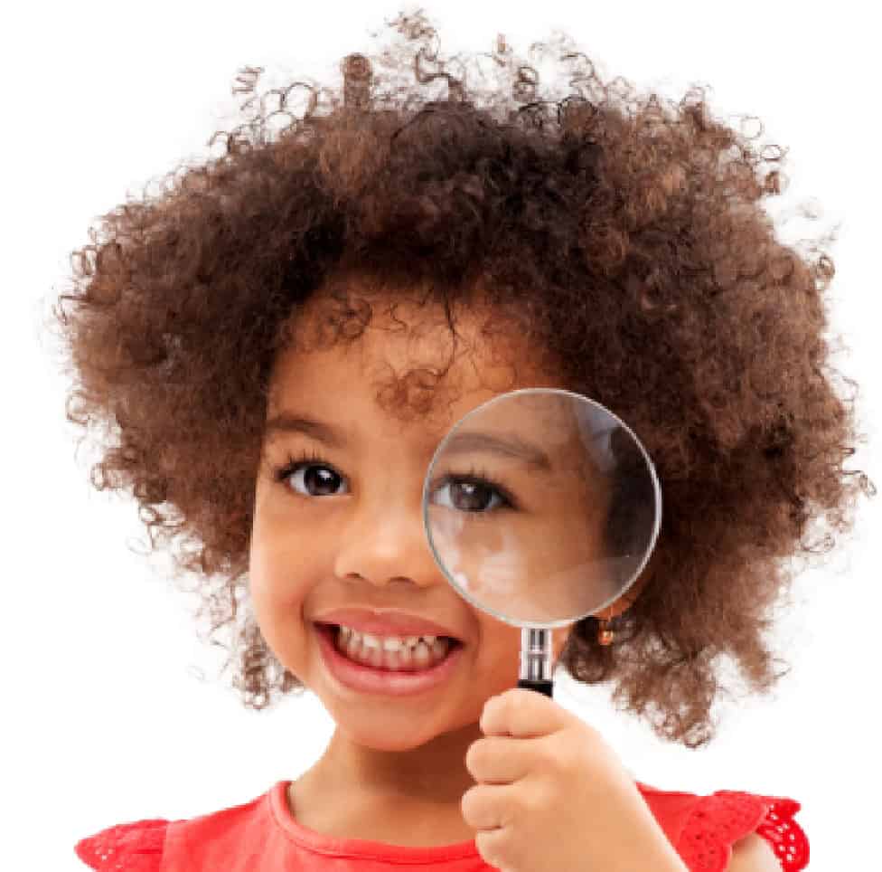 Young girl with curly hair holding a magnifying glass, representing curiosity and learning at Thrive Childcare, focusing on early childhood education, child development, and nurturing environments.