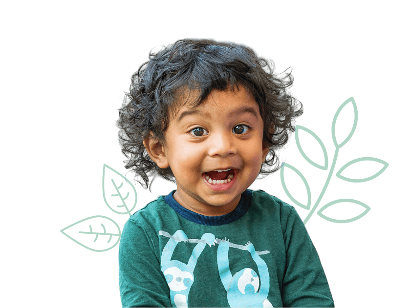 Bright young child with curly hair smiling at Thrive Childcare, highlighting our welcoming environment for early childhood development and learning in a safe, nurturing setting.