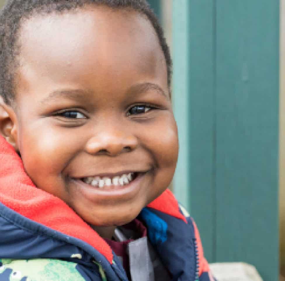 Bright smiling child at Thrive Childcare, engaging in colourful outdoor activities, promoting early childhood development, learning, and play in a caring environment.