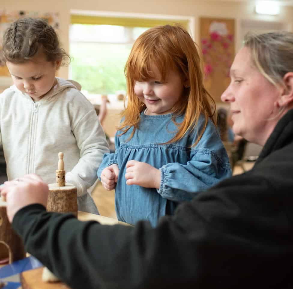 Active preschool children engaging in hands-on learning at Thrive Childcare, supported by caring staff in a bright, nurturing environment.