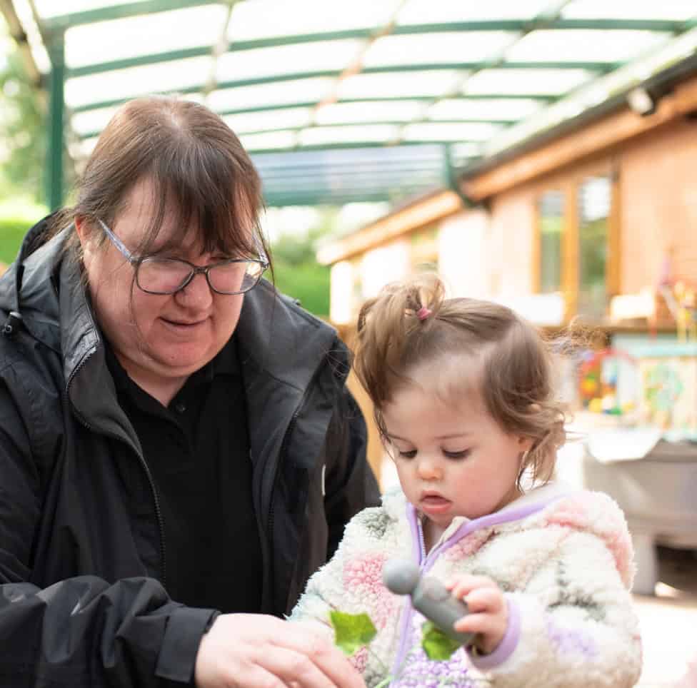 Comfortable preschool childcare environment at Thrive Childcare with nurturing staff engaging children in outdoor activities.