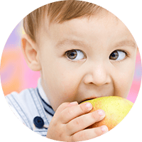 Bright young child enjoying a healthy apple, symbolising nutritious snacks and child wellbeing at Thrive Childcare, committed to nurturing healthy habits.