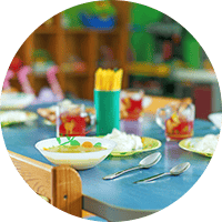 Brightly decorated children's dining area at Thrive Childcare, featuring healthy food options, colourful utensils, and engaging play elements for a fun, nurturing early learning environment.