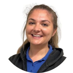 Friendly childcare staff member at Thrive Childcare smiling and wearing a blue uniform, providing a warm and caring environment for children.