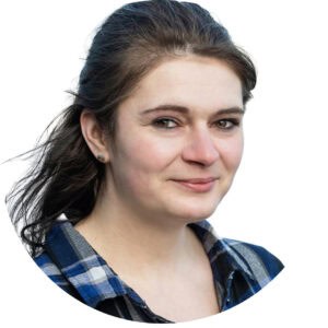 Friendly young woman smiling outdoors, representing childcare professionalism and nurturing environment at Thrive Childcare.