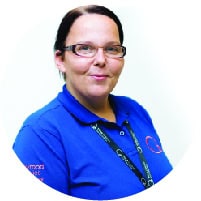 Caring childcare staff member in a blue uniform at Thrive Childcare, promoting safe and nurturing early childhood education services in the UK.