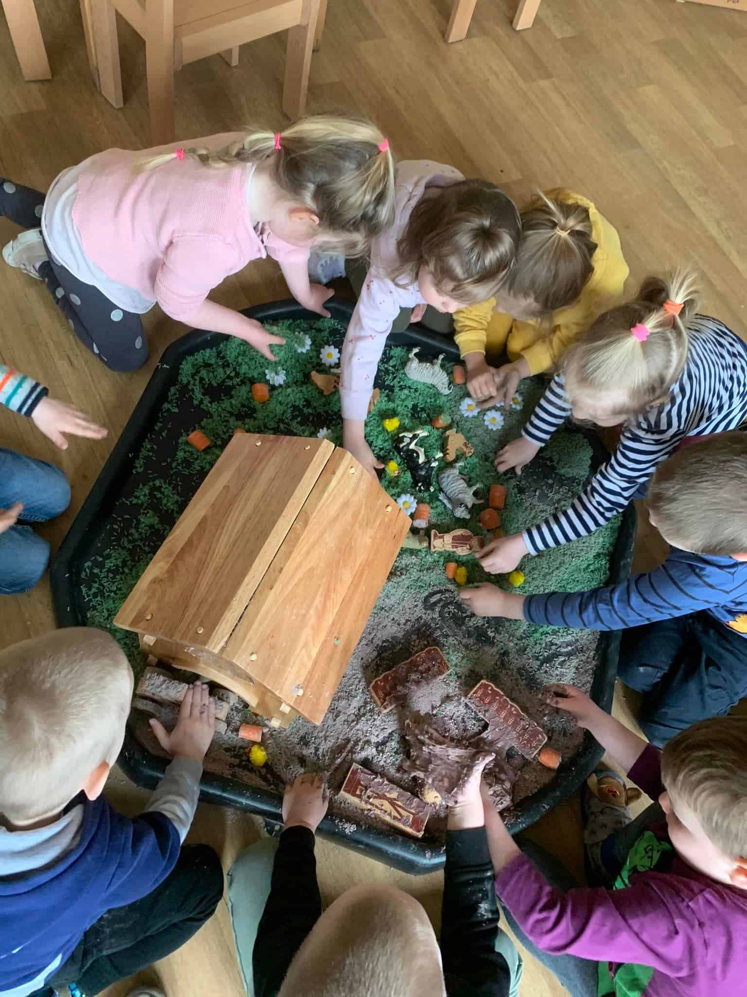 Children engaging in imaginative play with a sandbox at Thrive Childcare, fostering creativity, social skills, and outdoor learning in a safe, nurturing environment.