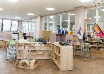 Bright and welcoming childcare classroom with engaging learning stations, colourful toys, and child-friendly furniture, promoting a nurturing environment for early childhood development.
