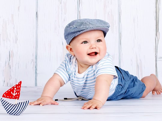 Adorable baby boy playing on the floor, promoting early childhood development and quality childcare services at Thrive Childcare.