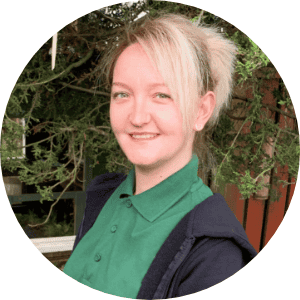 Bright smiling childcare professional at Thrive Childcare, engaging young children in fun educational activities in a safe, nurturing environment.