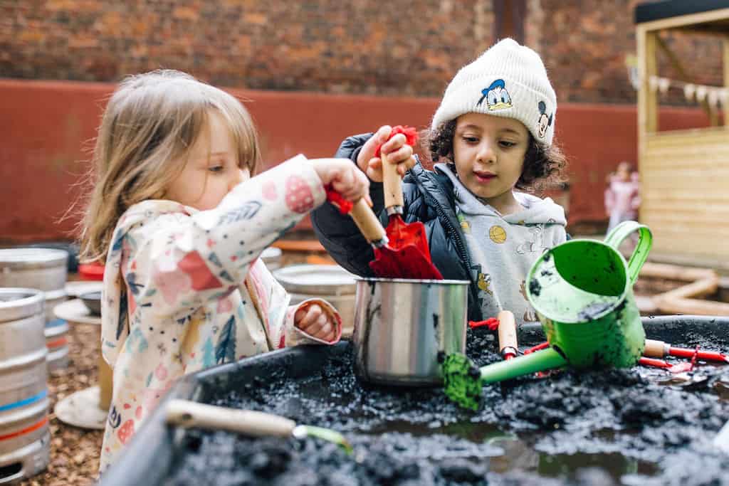 Children engaging in outdoor gardening activities at Thrive Childcare, developing early learning skills in a nurturing environment.