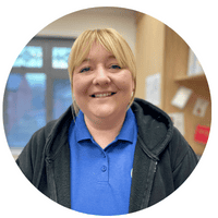 Happy childcare worker smiling indoors at Thrive Childcare, showcasing a caring environment for children's development and early education.