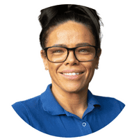 Kindergarten teacher smiling, wearing glasses and a blue uniform, supporting early childhood education and care services at Thrive Childcare.