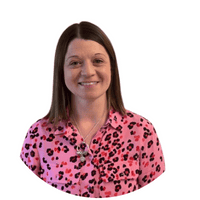 A smiling childcare professional in a colourful pink leopard print top, representing Thrive Childcare staff ready to support children's development and learning.