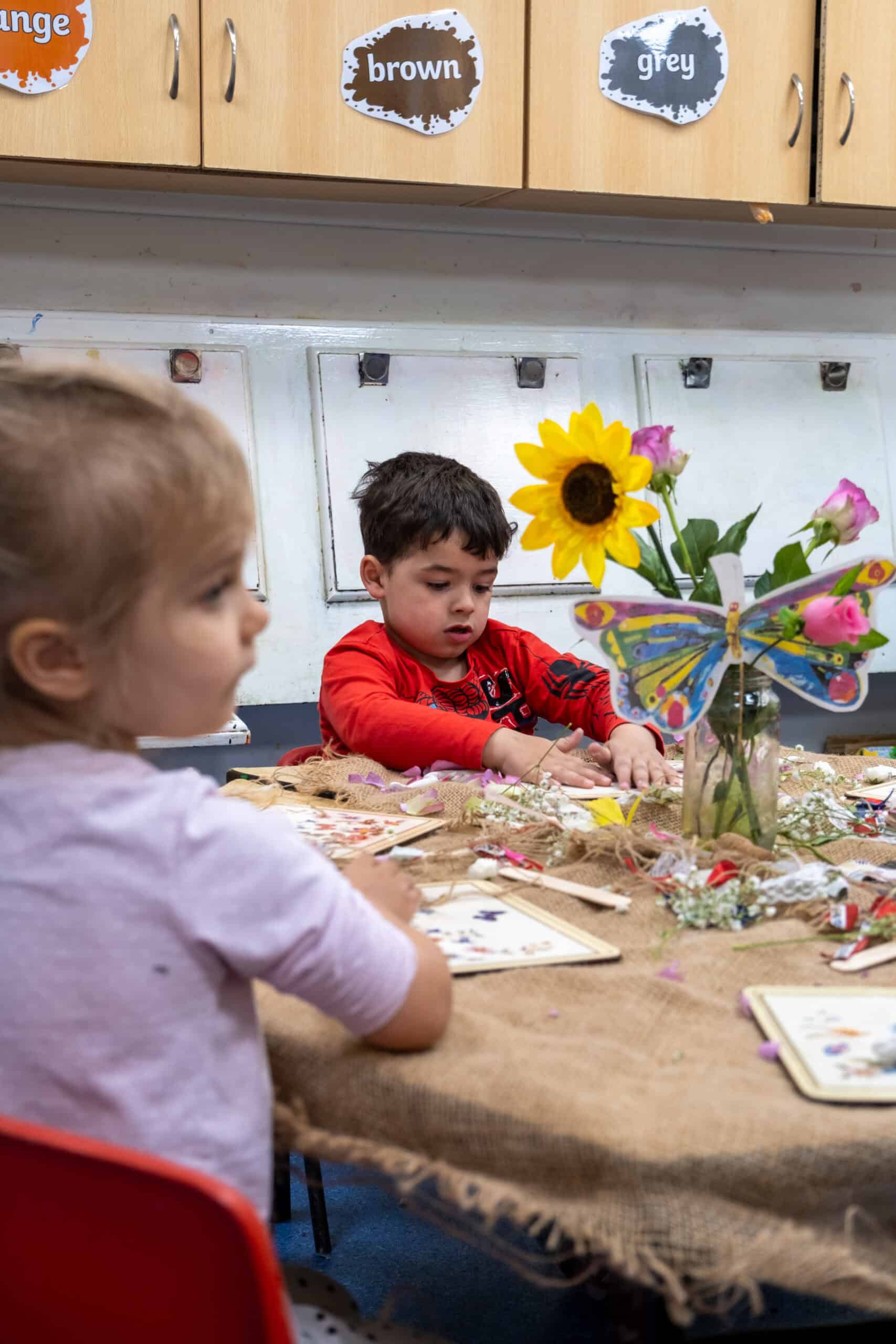 Tiny children engaging in creative arts and crafts activities at Thrive Childcare, showcasing a colourful and nurturing environment for early childhood development and learning.