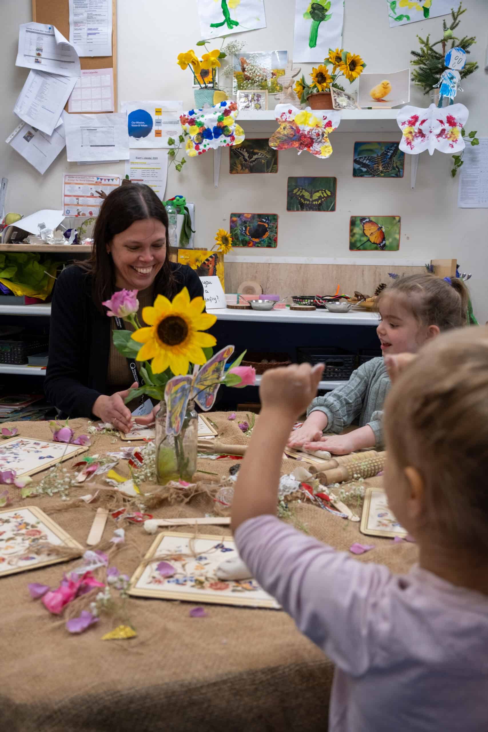Bright and cheerful classroom at Thrive Childcare, featuring engaging arts and crafts activities with children and staff, fostering creativity, learning, and social interaction.