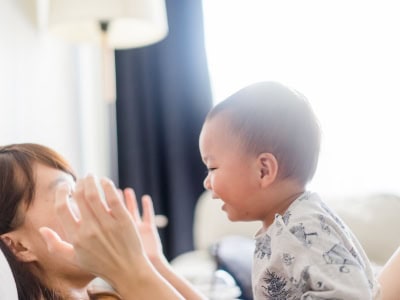 Happy toddler playing and smiling with caregiver at Thrive Childcare, fostering early childhood development and professional childcare services in a caring environment.
