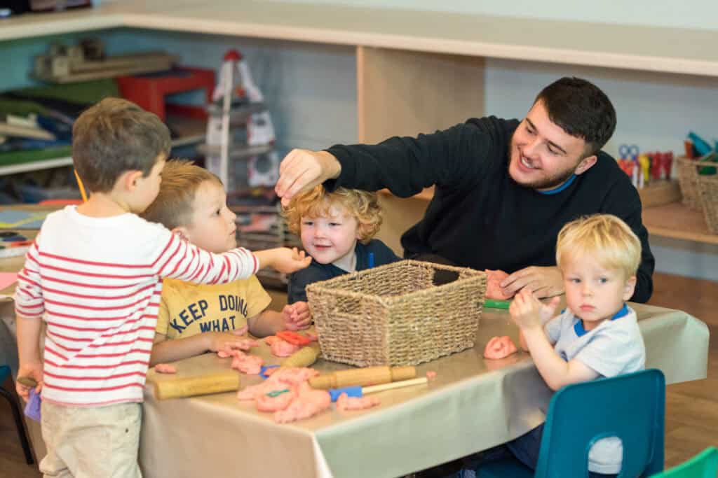 Playing and learning in a welcoming childcare environment with caring staff at Thrive Childcare, supporting early childhood development and social skills for children.