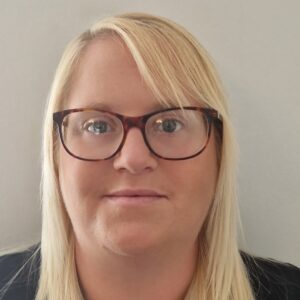 Childcare professional with blonde hair and glasses, promoting trusted early years education and caring services at Thrive Childcare.