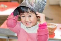 Bright-eyed young girl smiling and playing inside a colourful childcare centre, representing happy early childhood education at Thrive Childcare.
