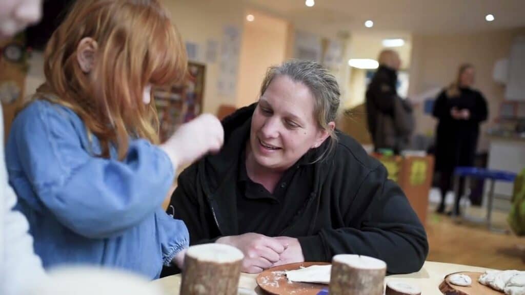 A1. Caring childcare staff engaging with children in a warm, friendly environment at Thrive Childcare, promoting early learning and developmental play in a welcoming local nursery setting.