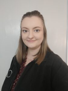 Bright young woman smiling, representing caring staff at Thrive Childcare, ensuring safe, nurturing environment for children's early learning and development in a professional childcare setting.