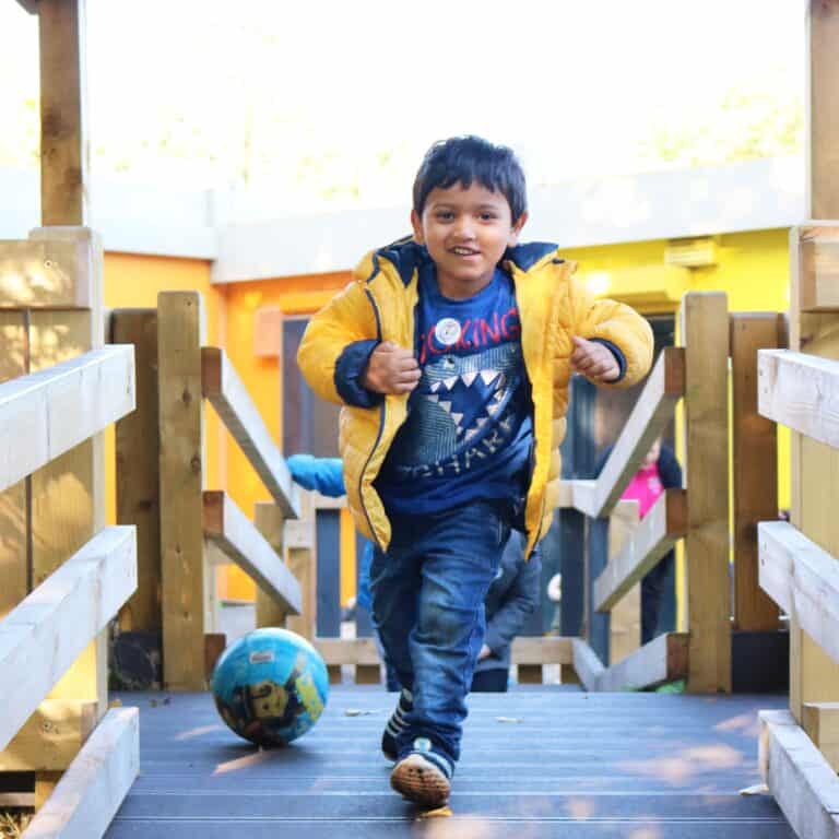 Playing outdoors at Thrive Childcare with children engaging in active play and sports.