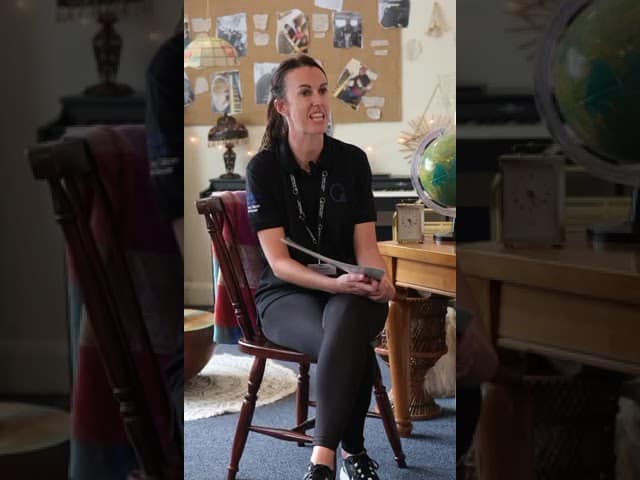 Friendly female teacher engaging with children in a vibrant childcare classroom, promoting early education and creative activities to support children's development.