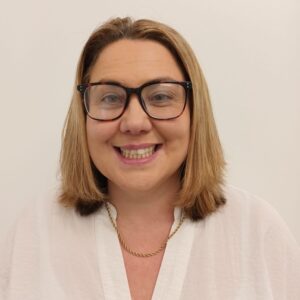 Caring childcare professional at Thrive Childcare smiling in a welcoming environment.