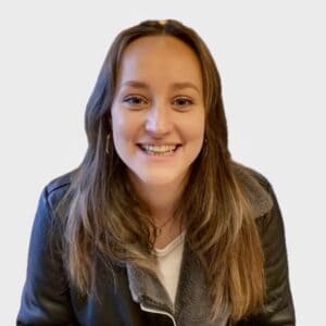 Friendly female childcare professional at Thrive Childcare, smiling and engaging with young children in a nurturing environment.