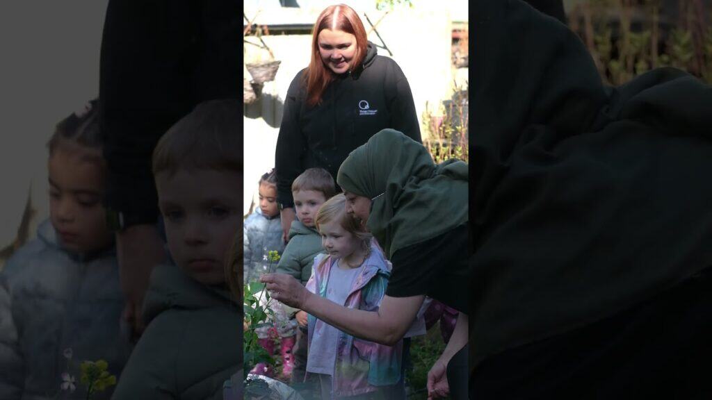 Children engaging in outdoor nature activities at Thrive Childcare, learning about plants and gardening with caring staff support.