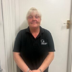 Experienced childcare professional at Thrive Childcare wearing a black polo shirt, providing warm, attentive care for children in a welcoming environment.