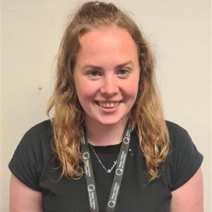 Bright, friendly childcare professional smiling in a Thrive Childcare setting, highlighting quality early years education and caring staff.