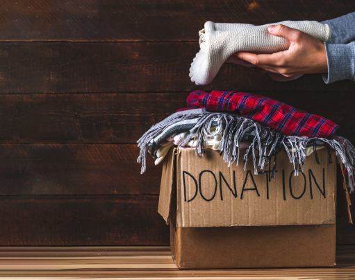 Used clothing donation box with folded clothes for charity and community support at Wildflower Home.