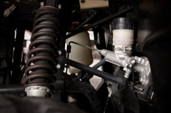 Close-up of off-road vehicle suspension with coil spring and shock absorber.
