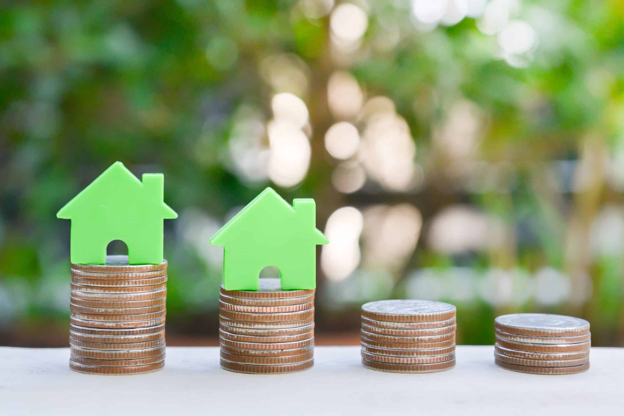 Home model on the growing coin stack for concept of money saving