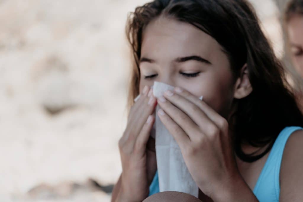 Young Girl Blowing Her Nose with Tissue