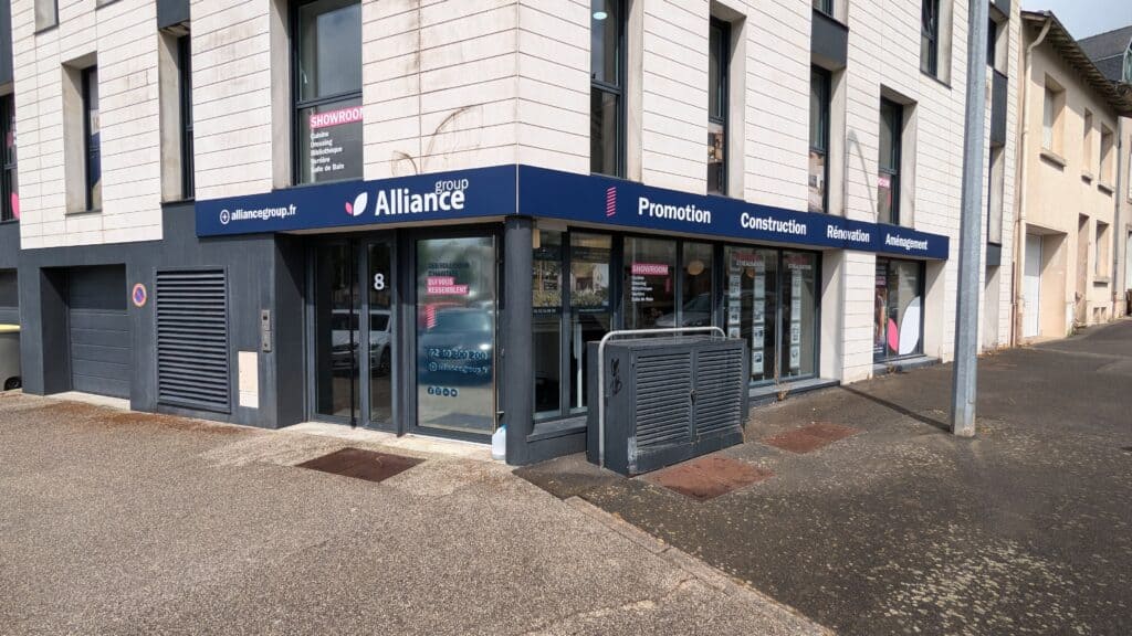 Façade d’une agence Alliance mettant en avant ses services de promotion, construction, rénovation et aménagement, avec des vitrines modernes, un showroom signalé et un emplacement en centre urbain accessible. - CHOLET vue de la place de la république
